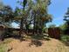 Large backyard with mature trees providing plenty of shade and a storage unit at 2033 Aaron Pl, Clearwater, FL 33760
