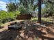 Spacious backyard featuring a fire pit, wooden swing, and mature trees at 2033 Aaron Pl, Clearwater, FL 33760
