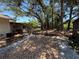 Large backyard area with rock features, bench, and mature trees at 2033 Aaron Pl, Clearwater, FL 33760