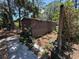 Wood shed featuring a small window, lush foliage, and walkway at 2033 Aaron Pl, Clearwater, FL 33760