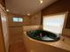 Bathroom featuring a standalone tub with fixtures, a window, and tiled walls for a luxurious bathing experience at 2033 Aaron Pl, Clearwater, FL 33760