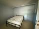 Bedroom features a twin sized bed with a metal frame and neutral colored walls and flooring at 2033 Aaron Pl, Clearwater, FL 33760