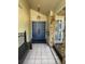 Covered entryway featuring double doors, stone columns, bench seating, and tile flooring at 2033 Aaron Pl, Clearwater, FL 33760