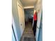 Hallway featuring wood floors, closet, and living room with wood paneled walls and a leather sofa at 2033 Aaron Pl, Clearwater, FL 33760