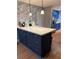 Kitchen with blue cabinetry, white countertops, patterned wallpaper and a large center island at 2033 Aaron Pl, Clearwater, FL 33760