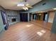 Spacious living room with wood floors, fireplace, and mirrored wall adjacent to the dining area at 2033 Aaron Pl, Clearwater, FL 33760