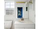 A clean bathroom boasts a white sink vanity, toilet, and a mirror offering depth at 21608 Wytheville Way, Lutz, FL 33549