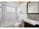 Bright bathroom featuring white cabinets, tub, and a dark vanity at 21608 Wytheville Way, Lutz, FL 33549