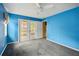 Cozy bedroom with plush gray carpet, a ceiling fan, and glass doors to the outside at 21608 Wytheville Way, Lutz, FL 33549