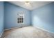 Light-blue bedroom with a window and neutral carpet at 21608 Wytheville Way, Lutz, FL 33549