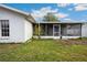 Exterior of the home shows enclosed patio with a small tree with red flowers, and white exterior at 21608 Wytheville Way, Lutz, FL 33549