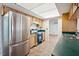 Bright kitchen features stainless steel fridge, tile floors, and light wood cabinets at 21608 Wytheville Way, Lutz, FL 33549
