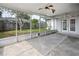 View of the spacious enclosed patio with ceiling fans and door to the backyard, which has a wood fence at 21608 Wytheville Way, Lutz, FL 33549