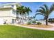 Home exterior featuring a lush green yard, stone walkway, and tropical landscaping at 24197 Treasure Island Blvd., Punta Gorda, FL 33955