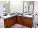 Dual sink vanity in a bathroom with wooden cabinets, light blue countertop, and matching mirrors at 24197 Treasure Island Blvd., Punta Gorda, FL 33955