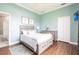 Well-lit bedroom with light blue walls, hardwood flooring, and a comfortable queen bed at 24197 Treasure Island Blvd., Punta Gorda, FL 33955
