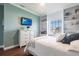 Inviting bedroom with mounted TV, built-in shelves, and a sunny window view at 24197 Treasure Island Blvd., Punta Gorda, FL 33955
