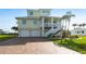 Charming two-story home with palm trees, a two-car garage and a welcoming staircase leading to the entrance at 24197 Treasure Island Blvd., Punta Gorda, FL 33955