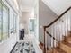 Inviting foyer with a decorative glass front door, hardwood floors, and an elegant staircase at 24197 Treasure Island Blvd., Punta Gorda, FL 33955
