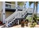 Inviting entrance staircase with white railings, dark grey steps and decorative potted plants at 24197 Treasure Island Blvd., Punta Gorda, FL 33955