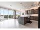 Open-concept kitchen boasts modern pendant lighting, an island with seating, stainless steel appliances, and beautiful balcony views at 24197 Treasure Island Blvd., Punta Gorda, FL 33955