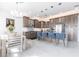 Modern kitchen and dining area features stainless steel appliances, a kitchen island, seating, and chandelier lighting at 24197 Treasure Island Blvd., Punta Gorda, FL 33955