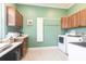 Charming laundry room with wood cabinets, washer, dryer and folding station at 24197 Treasure Island Blvd., Punta Gorda, FL 33955