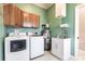 Functional laundry room with modern appliances, utility sink, and green walls at 24197 Treasure Island Blvd., Punta Gorda, FL 33955