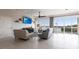 Light-filled living room boasts wood-look flooring, comfortable seating, a ceiling fan, and balcony access with lovely water views at 24197 Treasure Island Blvd., Punta Gorda, FL 33955