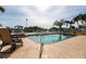 Outdoor pool and patio with chairs and an American flag in the background at 24197 Treasure Island Blvd., Punta Gorda, FL 33955