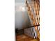 Detailed view of the wooden staircase with white spindles and a decorative chandelier above at 24197 Treasure Island Blvd., Punta Gorda, FL 33955