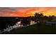 Scenic waterfront view featuring a vibrant sunset over calm waters and lush landscaping with palm trees at 24197 Treasure Island Blvd., Punta Gorda, FL 33955