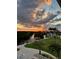 Beautiful sunset view of the waterfront and nearby homes with verdant landscaping, tropical palms, and boat docks at 24197 Treasure Island Blvd., Punta Gorda, FL 33955