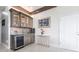 Elegant wet bar featuring custom cabinetry, a wine cooler, pendant lighting, and stylish accents at 24197 Treasure Island Blvd., Punta Gorda, FL 33955