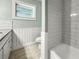 Clean bathroom with white subway tile, wood-look floors, and light green walls at 2479 Trade Winds Dr, Dunedin, FL 34698