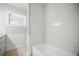 Bright bathroom featuring white subway tiles, wood-look floors, and a soaking tub at 2479 Trade Winds Dr, Dunedin, FL 34698
