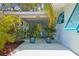 Charming front porch featuring colorful accents, lush plants, and a welcoming entryway at 2479 Trade Winds Dr, Dunedin, FL 34698
