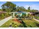 Charming single-story home with a well-manicured front yard featuring palm trees and a walkway at 2479 Trade Winds Dr, Dunedin, FL 34698