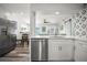 Modern kitchen featuring stainless steel appliances, white cabinetry, and an open layout connecting to the living area at 2479 Trade Winds Dr, Dunedin, FL 34698