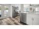 The kitchen features stainless steel appliances, white cabinetry, and wood floors, with pool view at 2479 Trade Winds Dr, Dunedin, FL 34698