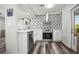 Modern kitchen with white cabinets, stainless steel appliances, and geometric tile backsplash at 2479 Trade Winds Dr, Dunedin, FL 34698