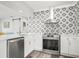 Modern kitchen with stainless steel appliances, white cabinets, and stylish backsplash at 2479 Trade Winds Dr, Dunedin, FL 34698