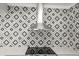 A kitchen featuring a modern stainless steel range hood and eye-catching geometric tile backsplash at 2479 Trade Winds Dr, Dunedin, FL 34698