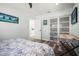 Serene bedroom with a patterned bedspread, sliding closet doors, and a dedicated workspace with a modern desk at 2479 Trade Winds Dr, Dunedin, FL 34698