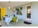 Charming outdoor dining area with a yellow door and modern art piece at 2479 Trade Winds Dr, Dunedin, FL 34698