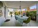 Covered outdoor dining area with a large table and lush tropical plants at 2479 Trade Winds Dr, Dunedin, FL 34698