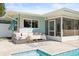 Inviting outdoor patio with a pool and screened-in porch featuring stylish seating and decor, perfect for entertaining at 2479 Trade Winds Dr, Dunedin, FL 34698