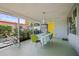 The covered patio provides a tranquil space with its vintage yellow decor and colorful plants at 2479 Trade Winds Dr, Dunedin, FL 34698
