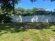 A spacious fenced backyard with green grass and mature trees at 2709 S Manhattan Ave, Tampa, FL 33629