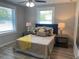 Bedroom with two windows, hardwood flooring, ceiling fan, and two bedside tables at 2709 S Manhattan Ave, Tampa, FL 33629